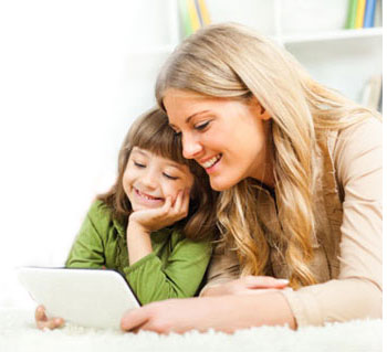 Mom and child smile as they learn together from a digital tablet.